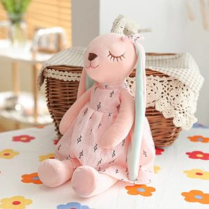 淡いピンクの小枝柄ワンピースを着た眠り目のうさぎぬいぐるみ